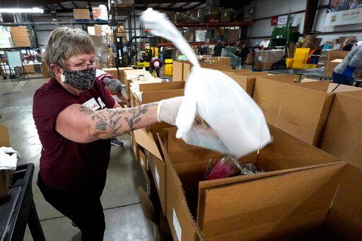 Volunteer Linda Nordin places a meat package into a box with other food at the Northern Illinois Food Bank to be delivered by DoorDash drivers for area residents who are homebound in Park City, Ill. Previously, the pantry