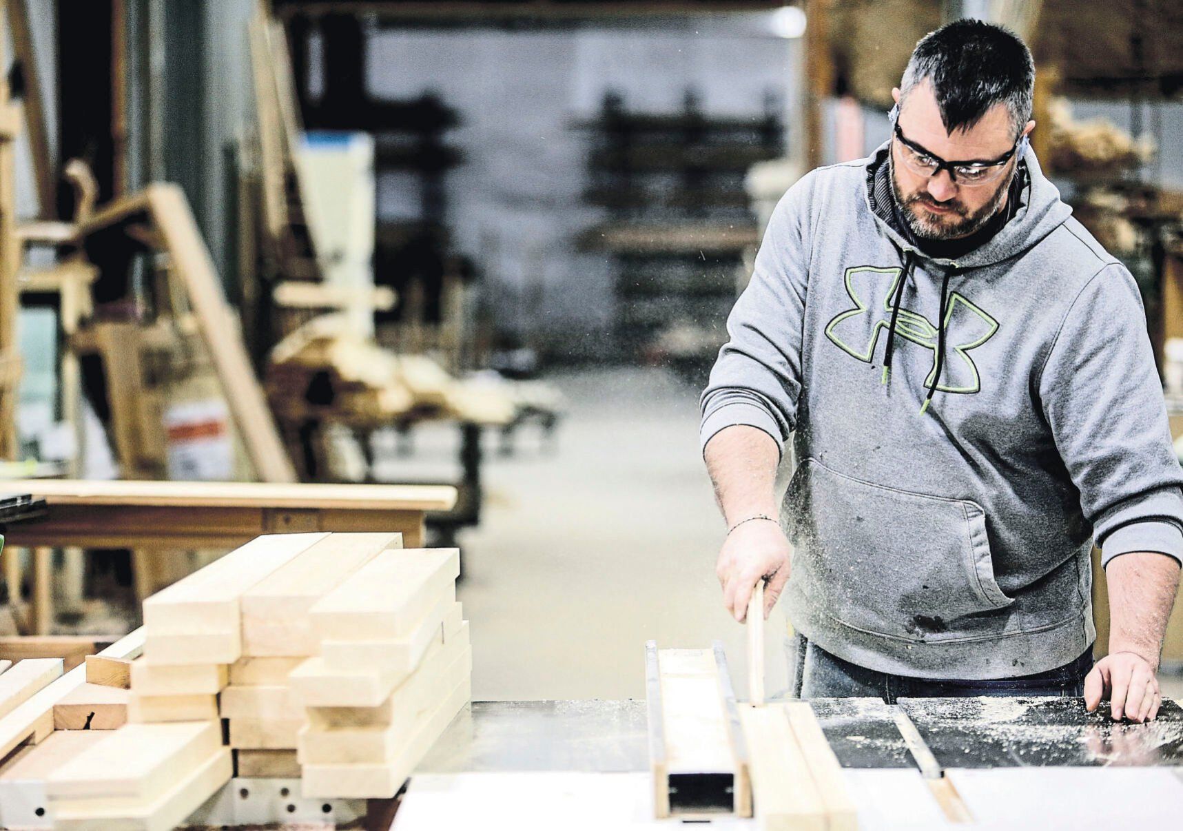 Josh Kruse cuts strips of wood while working at Dubuque Window & Door Co. The Dubuque-based company celebrates its 100th anniversary this year. In 2011, it changed its name from Dubuque Sash & Door and moved its facility to Kerper Boulevard.    PHOTO CREDIT: Dave Kettering