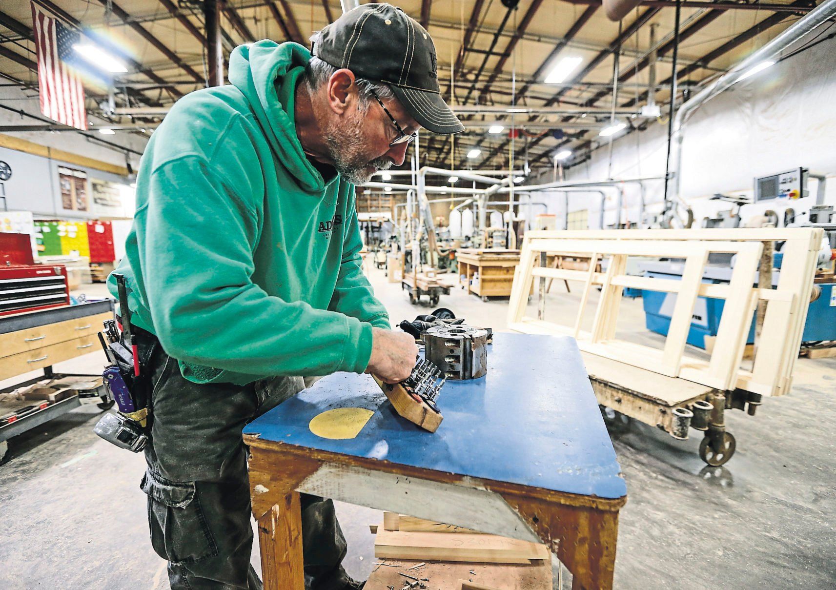 Jon Brachman works on setting up a cutting tool.    PHOTO CREDIT: Dave Kettering