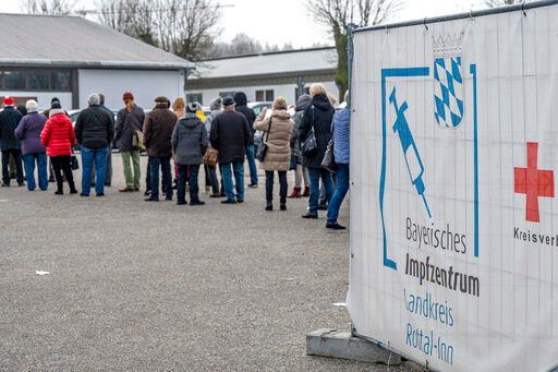 People stand in line in front of a COVID-19 vaccination center in Eggenfelden, Germany, Wednesday, Nov. 24, 2021. (Armin Weigel/dpa via AP)    PHOTO CREDIT: Armin Weigel