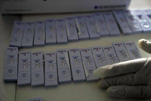 FILE - A member of the medical staff at the National Public Health Organisation (EODY) adjusts COVID-19 rapid tests in Athens, Greece, Monday, Nov. 15, 2021. The coronavirus