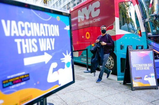 A man walks off a vaccination bus at a NYC mobile vaccine clinic in Midtown Manhattan, Monday, Dec. 6, 2021. Mayor Bill de Blasio says all New York City employers will have to mandate COVID-19 vaccinations for their workers by Dec. 27. (AP Photo/Mary Altaffer)    PHOTO CREDIT: Mary Altaffer