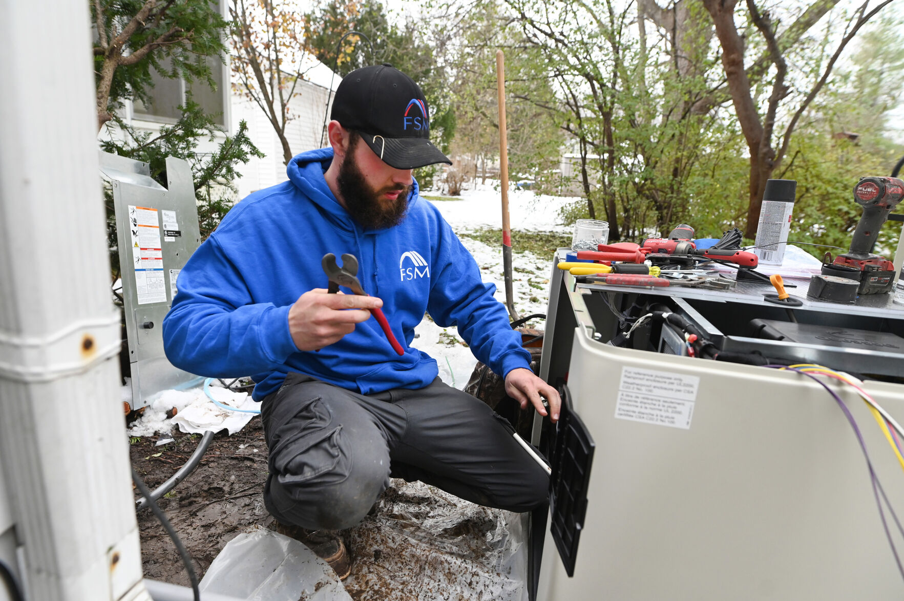Chris Buckner, electrician, Foundation Systems Michigan, installs a Cummins whole house generator in Ypsilanti, Mich., as increasing demand for generators and as people work from home and following this summer