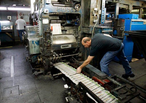 A pressman grabs a freshly printed paper off the press at the St. Louis Post-Dispatch