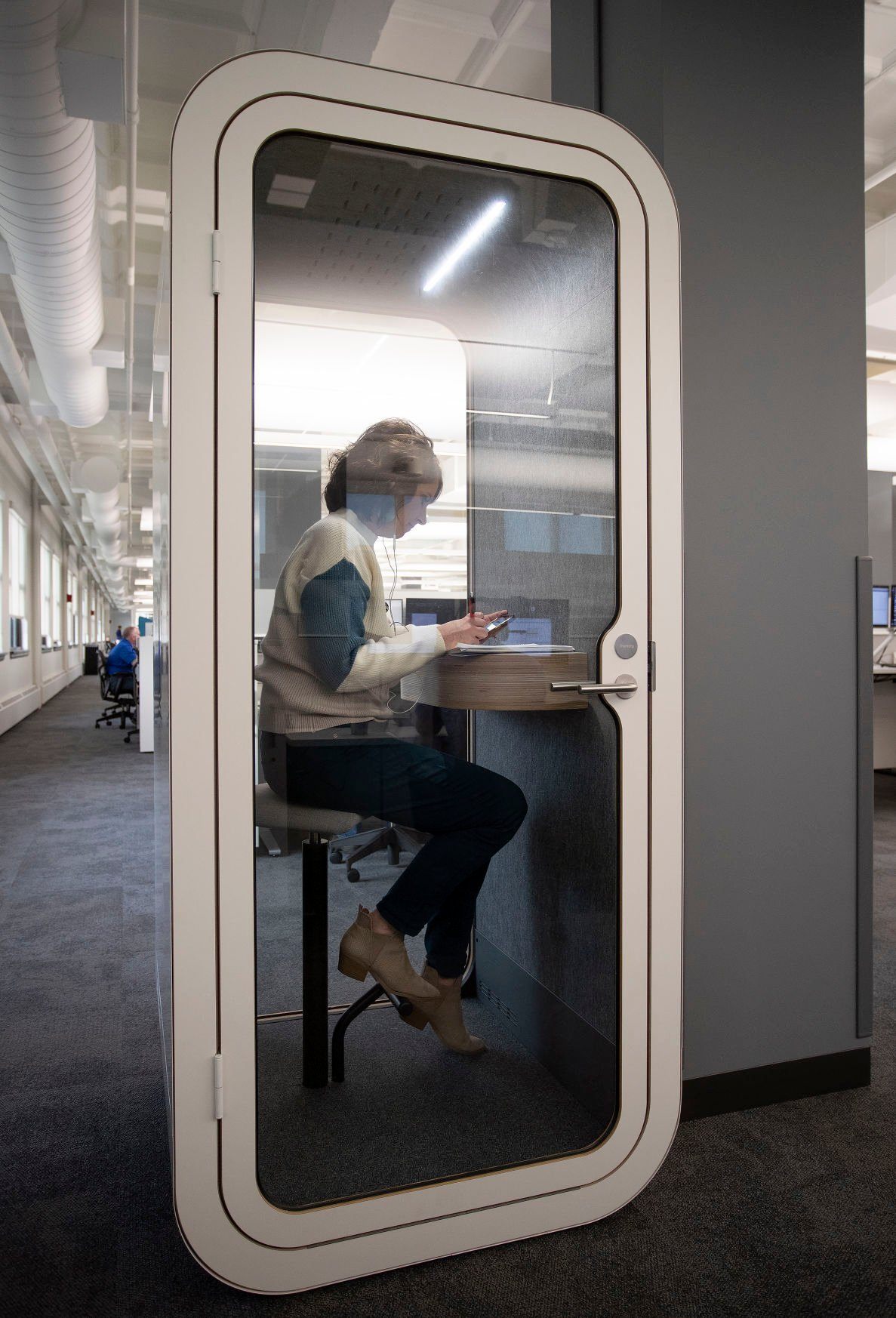 Tracy Bechen uses a sound-proof “phone booth” to take a call on Wednesday in the recently renovated building at 700 Locust St. in Dubuque.    PHOTO CREDIT: Stephen Gassman