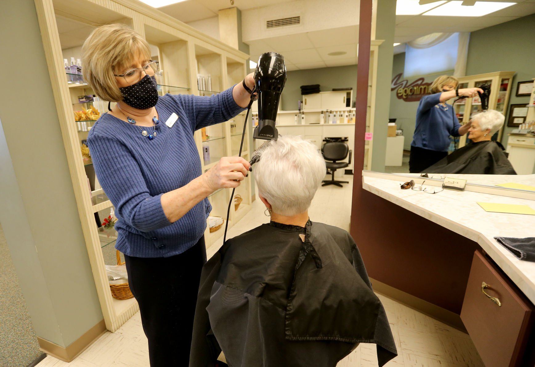 Co-owner Carole Nauman styles hair for Eileen Schueller, of Dubuque, at Amirage Salon, Day Spa and Hair Loss Center in Dubuque on Thursday, Dec. 16, 2021. Nauman will retire on Thursday, Dec. 23.    PHOTO CREDIT: JESSICA REILLY