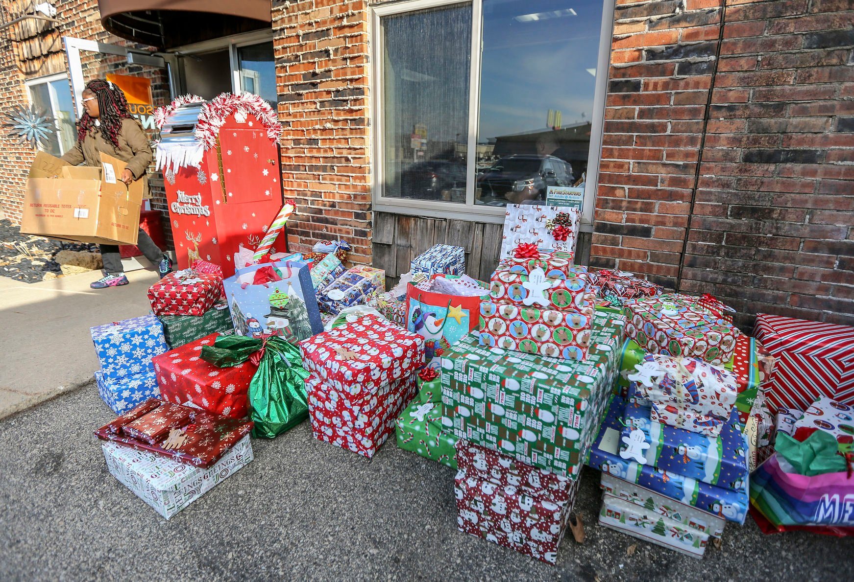 Tiffany Welton, of Dubuque, picks up Christmas gifts at Resources Unite on Monday. The nonprofit provides gifts for families in need. The organization will provide gifts to more than 1,150 kids this holiday season, after serving about 1,000 last year.    PHOTO CREDIT: Dave Kettering