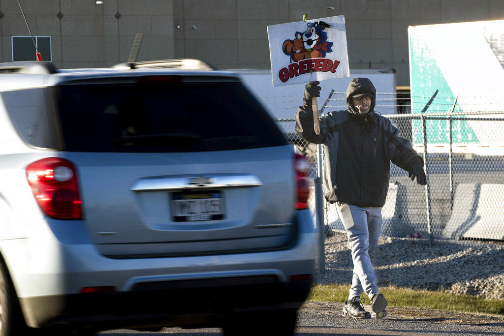 Rodney Conyers Sr. holds a sign outside the Kellogg