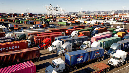 FILE - Trucks line up to enter a Port of Oakland shipping terminal on Wednesday, Nov. 10, 2021, in Oakland, Calif. The U.S. economy grew at a 2.3% rate in the third quarter, the Commerce Department said Wednesday, Dec. 22. But prospects for a solid rebound going forward are being clouded by rising worries about the rapid spread of the new omicron virus. (AP Photo/Noah Berger, File)    PHOTO CREDIT: Noah Berger