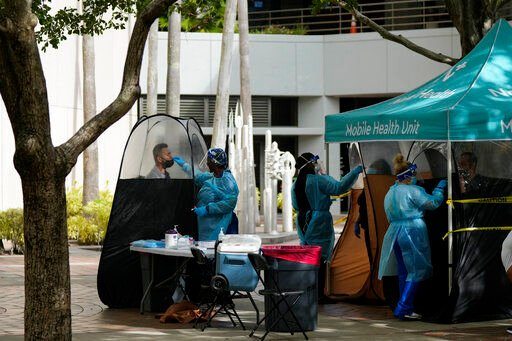 People are tested for COVID-19, at a walk-up testing site run by Nomi Health in downtown Miami. More than a year after the vaccine was rolled out, new cases of COVID-19 in the U.S. have soared to the highest level on record at more than 265,000 per day on average, a surge driven largely by the highly contagious omicron variant.    PHOTO CREDIT: Rebecca Blackwell