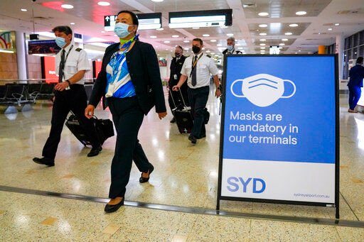 FILE - A flight crew walk through the terminal at Sydney Airport on Nov. 29, 2021. Caseloads of omicron have remained relatively low in many countries in Asia. For now, many remain insulated from the worst, although the next few months will remain critical. (AP Photo/Mark Baker, File)    PHOTO CREDIT: Mark Baker