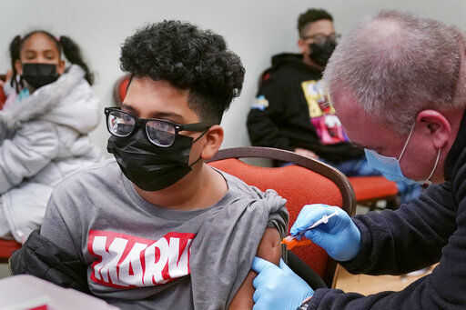 Avgieo Lopez, 10, of Lawrence, Mass., receives his first shot of the Pfizer COVID-19 vaccine, as his siblings wait for their turn, during a vaccination clinic at City of Lawrence