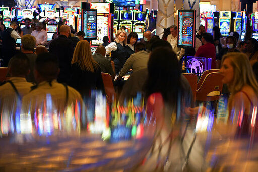 FILE - In this June 24, 2021, file photo, visitors crowd the casino during the opening night of the Resorts World Las Vegas hotel-casino in Las Vegas. Nevada casinos set a record in November, reporting a ninth straight month of $1 billion or more in house winnings in a sign that business in the nation