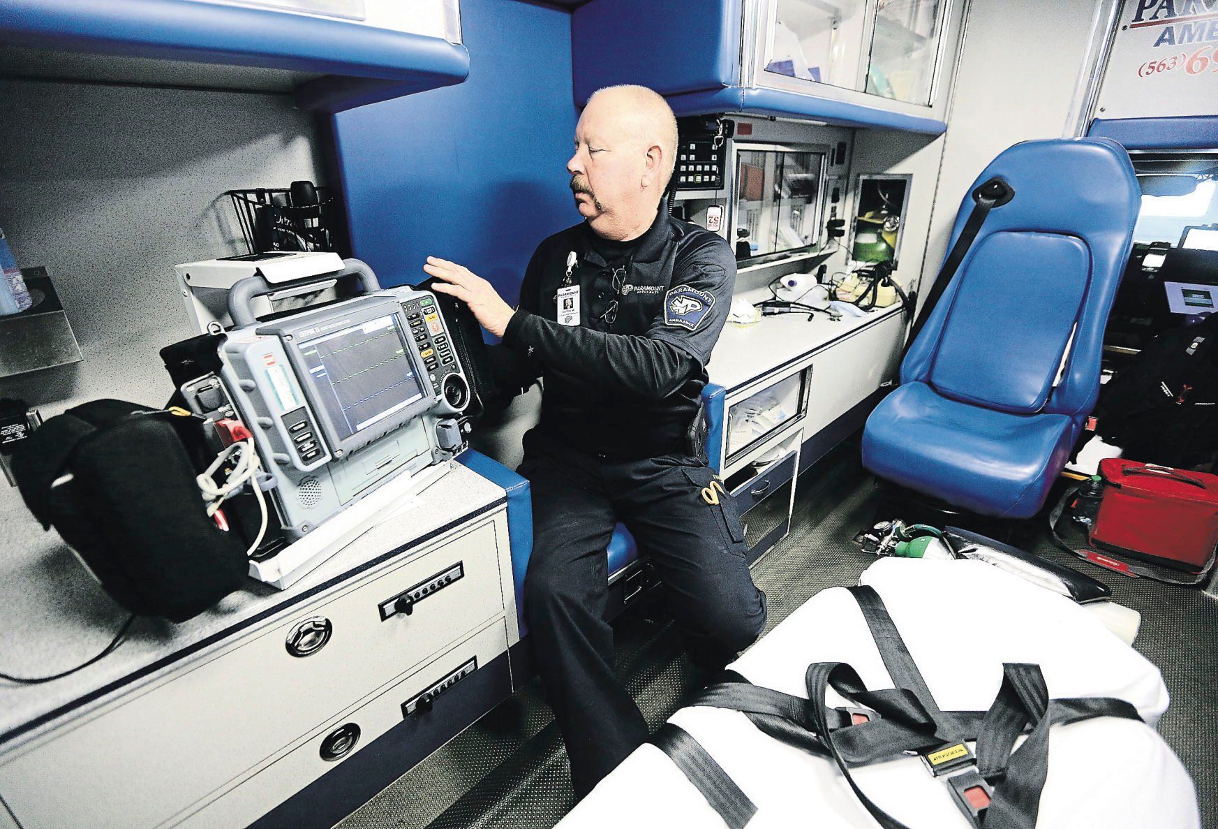 Paramount Ambulance employee Bartley Welch checks equipment inside one of the ambulances.    PHOTO CREDIT: Dave Kettering