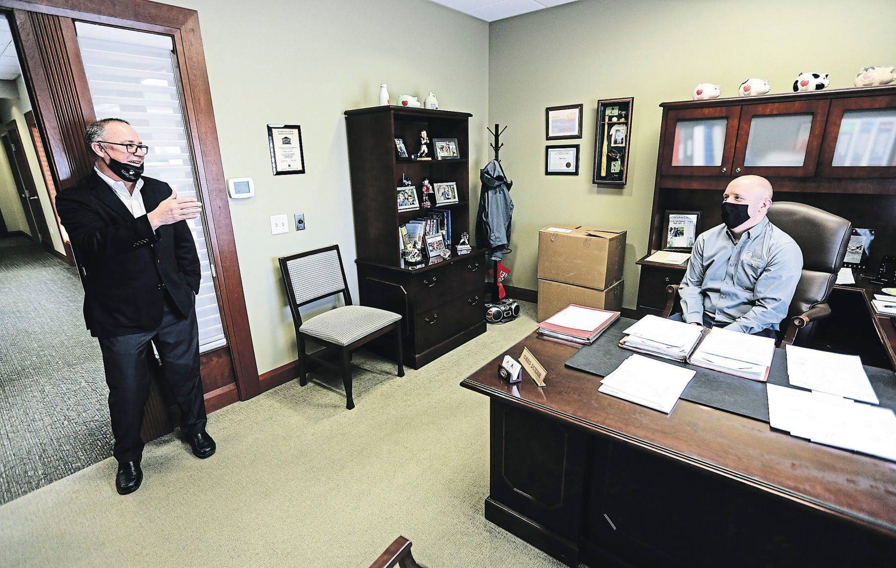 Chief Executive Officer Joel Holland (left), with First Community Bank of Galena (Ill.), talks with Chief Lending Officer Greg Duerr.    PHOTO CREDIT: Dave Kettering