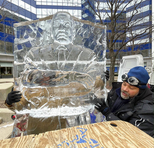 Sculptor Max Zuleta assembles an ice sculpture of Martin Luther King Jr. prior to a ceremony where the last few blocks of what was 3rd Street downtown that have been renamed Dr. Martin Luther King Jr. Drive at its intersection with W. Wisconsin Ave. Monday, Jan. 17, 2022 in Milwaukee, Wis. The 1400 pound ice sculpture took 14 hours to create, which is longer than normal, because the face had to be specific to King. He is from Franksville, Wis. (Mark Hoffman/Milwaukee Journal-Sentinel via AP)    PHOTO CREDIT: Mark Hoffman