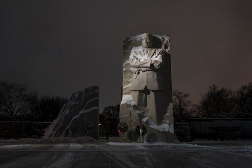 Snow covers the Martin Luther King Jr. Memorial in Washington, Sunday, Jan. 16, 2022. Ceremonies scheduled for the site on Monday, to mark the Martin Luther King Jr. national holiday, have been canceled because of the weather. (AP Photo/Carolyn Kaster)    PHOTO CREDIT: Carolyn Kaster