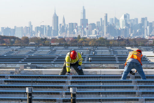 Framed by the Manhattan skyline electricians with IBEW Local 3 install solar panels on top of the Terminal B garage at LaGuardia Airport in the Queens borough of New York. As climate change pushes states in the U.S. to dramatically cut their use of fossil fuels, many are coming to the conclusion that solar, wind and other renewable power sources won