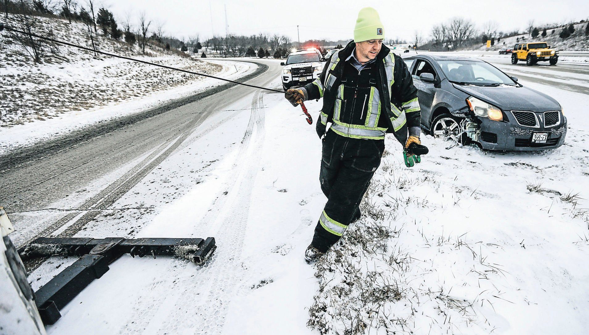 Kevin Barth, of Donnie’s Tire & Auto in Dickeyville, Wis., pulls a motorist out of a ditch after sliding off U.S. 151/61 near the Dubuque-Wisconsin bridge. Towing operators are busy in the winter. They often must battle the elements to perform their duties.    PHOTO CREDIT: Dave Kettering