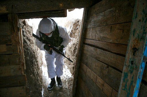 A serviceman walks along a trench on the territory controlled by pro-Russian militants near at frontline with Ukrainian government forces in Slavyanoserbsk, Luhansk region, eastern Ukraine, Tuesday, Jan. 25, 2022. Ukraine