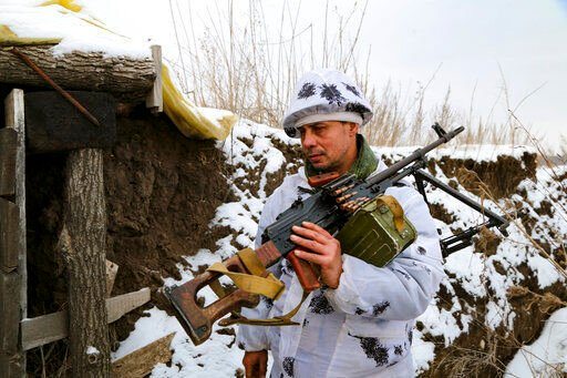 A serviceman carries his machine-gun into a shelter on the territory controlled by pro-Russian militants at frontline with Ukrainian government forces in Slavyanoserbsk, Luhansk region, eastern Ukraine, Tuesday, Jan. 25, 2022. Ukraine