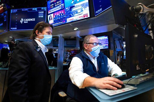 In this photo provided by the New York Stock Exchange, trader Michael Conlon, right, works on the floor, Tuesday, Jan. 25, 2022. Stocks fell sharply on Wall Street Tuesday, continuing a volatile bout of trading that has sent markets swinging between sharp losses and gains as investors gauge several threats. (Allie Joseph/New York Stock Exchange via AP)    PHOTO CREDIT: Allie Joseph