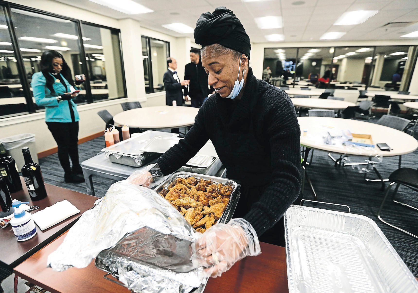 Francen Sanders, co-owner of Boaz BBQ in Dubuque, sets up food for a business mixer.    PHOTO CREDIT: Dave Kettering