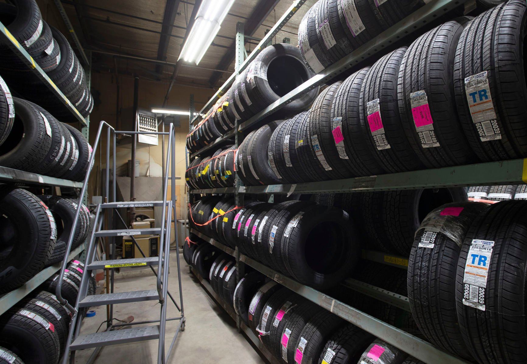 Tires stacked on shelves in the service center at Theisen