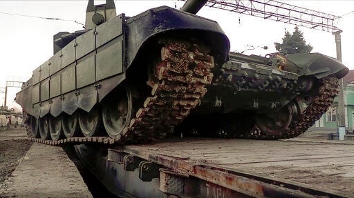 In this photo taken from video provided by the Russian Defense Ministry Press Service on Tuesday, Feb. 15, 2022, A Russian tank is loaded onto railway platforms after the end of military drills in South Russia. In what could be another sign that the Kremlin would like to lower the temperature, Russia