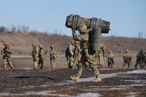 A Ukrainian serviceman carries an NLAW anti-tank weapon during an exercise in the Joint Forces Operation, in the Donetsk region, eastern Ukraine, Tuesday, Feb. 15, 2022. While the U.S. warns that Russia could invade Ukraine any day, the drumbeat of war is all but unheard in Moscow, where pundits and ordinary people alike don