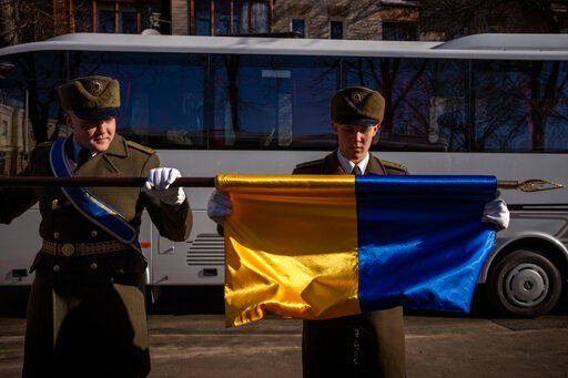 Honor guard soldiers fold an Ukraine flag following a ceremony to mark the anniversary of the withdrawal of Soviet troops from Afghanistan, in Kyiv, Ukraine, Tuesday, Feb. 15, 2022. Russia says that some units participating in military exercises will begin returning to their bases. That adds to glimmers of hope that the Kremlin may not be planning to invade Ukraine imminently. (AP Photo/Emilio Morenatti)    PHOTO CREDIT: Emilio Morenatti