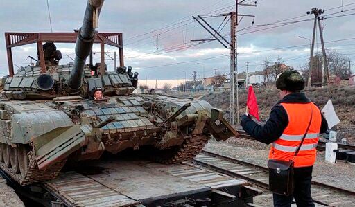 In this photo taken from video provided by the Russian Defense Ministry Press Service on Tuesday, Feb. 15, 2022, a Russian tank is loaded onto railway platforms after the end of military drills in South Russia. In what could be another sign that the Kremlin would like to lower the temperature, Russia