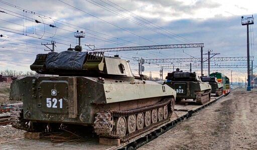 In this photo taken from video provided by the Russian Defense Ministry Press Service on Tuesday, Feb. 15, 2022, Russian armored vehicles are loaded onto railway platforms after the end of military drills in South Russia. In what could be another sign that the Kremlin would like to lower the temperature, Russia