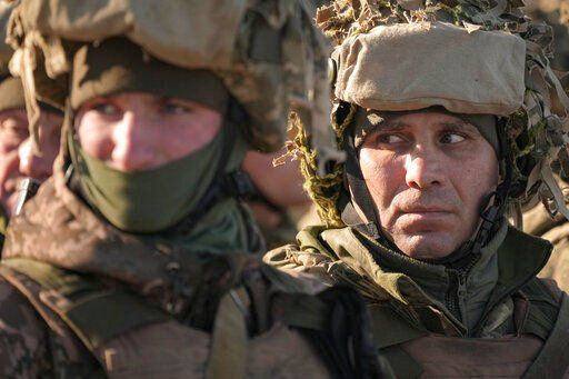 Ukrainian servicemen wait in formation before an exercise in the Joint Forces Operation, in the Donetsk region, eastern Ukraine, Tuesday, Feb. 15, 2022. While the U.S. warns that Russia could invade Ukraine any day, the drumbeat of war is all but unheard in Moscow, where pundits and ordinary people alike don