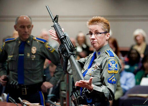 FILE - Firearms training unit Detective Barbara J. Mattson, of the Connecticut State Police, holds up a Bushmaster AR-15 rifle, the same make and model of gun used by Adam Lanza in the December 2012 Sandy Hook School shooting, during a hearing of a legislative subcommittee in Hartford, Conn., Jan. 28, 2013. The families of nine victims of the Sandy Hook Elementary School have agreed to a $73 million settlement of a lawsuit against the maker of the rifle used to kill 20 first graders and six educators in 2012. (AP Photo/Jessica Hill, File)    PHOTO CREDIT: Jessica Hill
