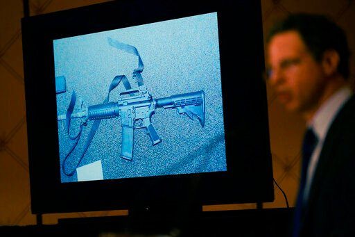 An image of the weapon used during the Newtown shooting is displayed while attorney Josh Koskoff speaks during a news conference in Trumbull, Conn., Tuesday, Feb. 15, 2022. The families of nine victims of the Sandy Hook Elementary School shooting have agreed to a $73 million settlement of a lawsuit against the maker of the rifle used to kill 20 first graders and six educators in 2012, their attorney said Tuesday. (AP Photo/Seth Wenig)    PHOTO CREDIT: Seth Wenig