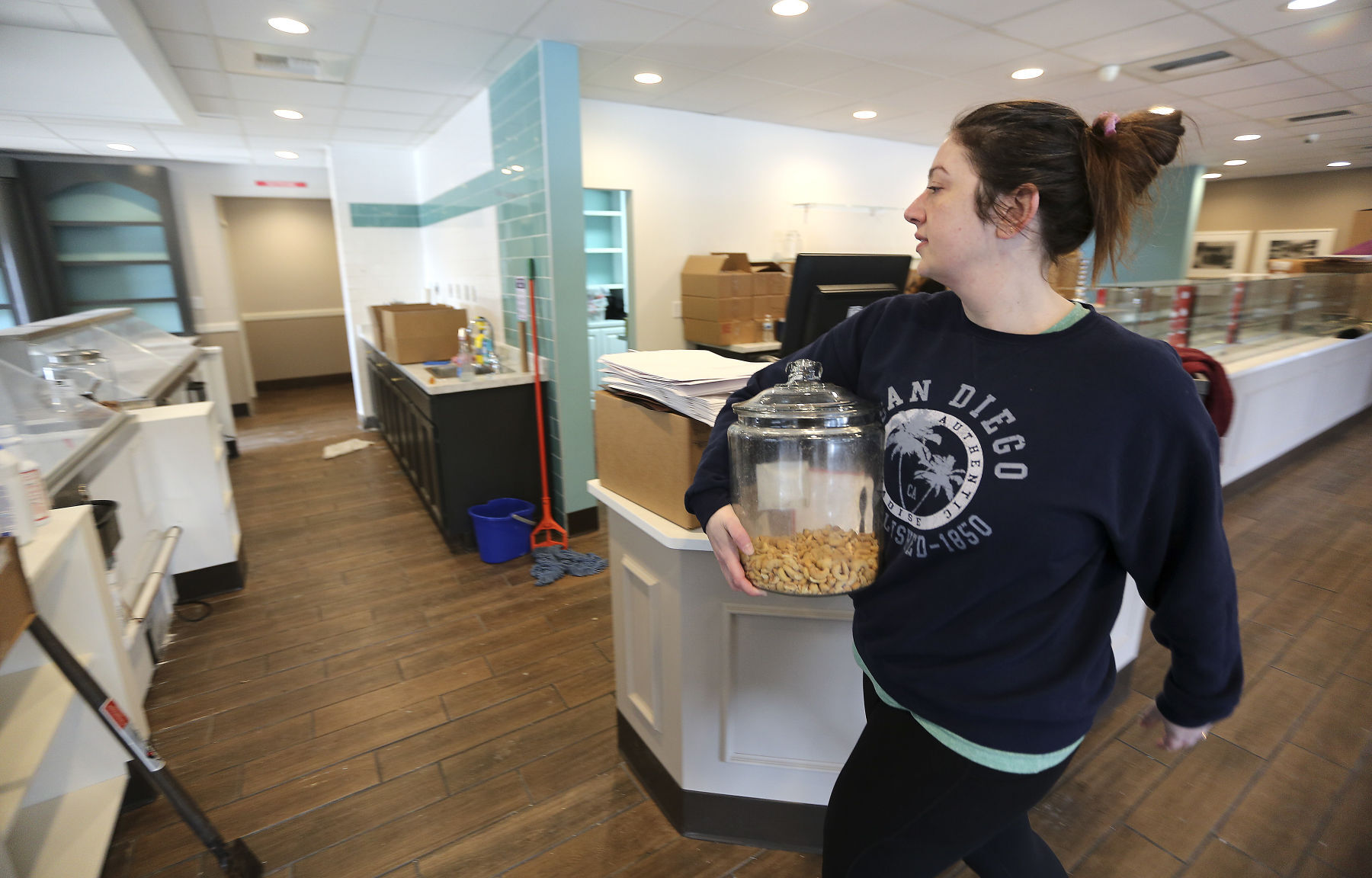 Betty Jane Candies Retail Manager Alexa Oettinger moves product into the new location on John F. Kennedy Road on Tuesday.    PHOTO CREDIT: Dave Kettering