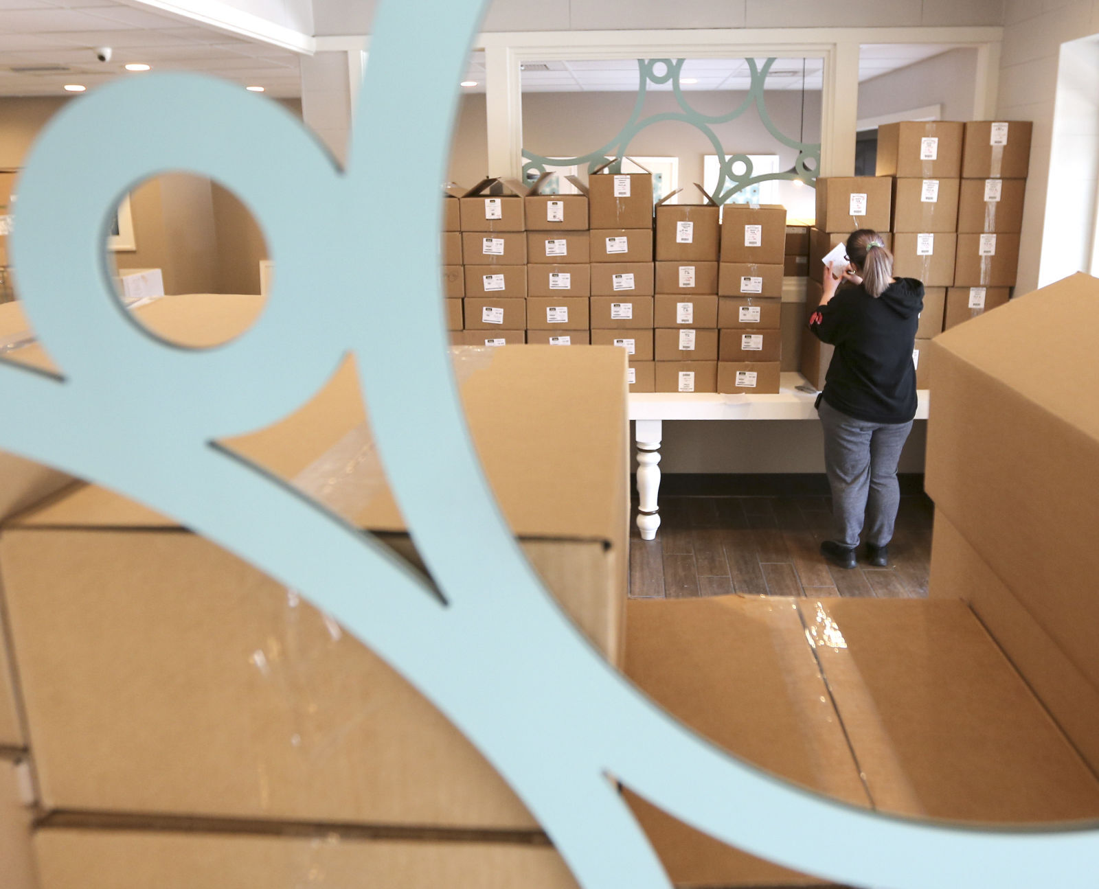 Betty Jane Candies employee Anna Billmyer works on inventory while moving into the new location on John F. Kennedy Road on Tuesday.    PHOTO CREDIT: Dave Kettering