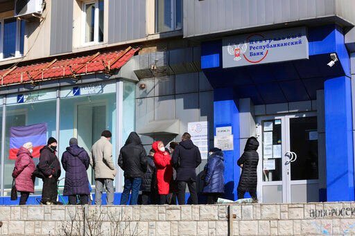 People line up to withdraw money from an ATM in Donetsk, the territory controlled by pro-Russian militants, eastern Ukraine, Monday, Feb. 21, 2022. World leaders are making another diplomatic push in hopes of preventing a Russian invasion of Ukraine, even as heavy shelling continues in Ukraine