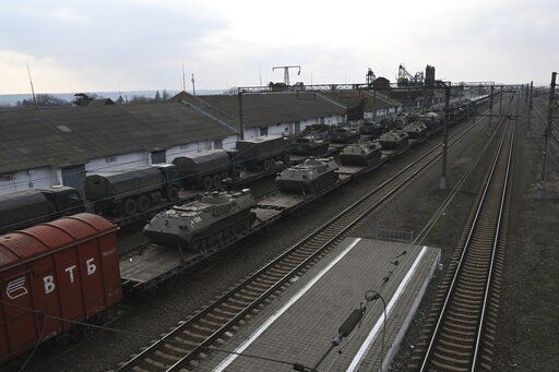 Russian armored vehicles are loaded onto railway platforms at a railway station in region not far from Russia-Ukraine border, in the Rostov-on-Don region, Russia, Wednesday, Feb. 23, 2022. U.S. President Joe Biden announced the U.S. was ordering heavy financial sanctions against Russia, declaring that Moscow had flagrantly violated international law in what he called the "beginning of a Russian invasion of Ukraine." (AP Photo)    PHOTO CREDIT: STR