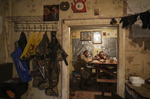 Ukrainian servicemen eat dinner after their duty at the frontline near Svitlodarsk, eastern Ukraine, Wednesday, Feb. 23, 2022. U.S. President Joe Biden announced the U.S. was ordering heavy financial sanctions against Russia, declaring that Moscow had flagrantly violated international law in what he called the "beginning of a Russian invasion of Ukraine." (AP Photo/Evgeniy Maloletka)    PHOTO CREDIT: Evgeniy Maloletka
