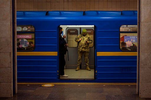 A Ukrainian army officer looks at his phone in a local train in Kyiv, Ukraine, Wednesday, Feb. 23, 2022. Ukraine urged its citizens to leave Russia as Europe braced for further confrontation Wednesday after Russia