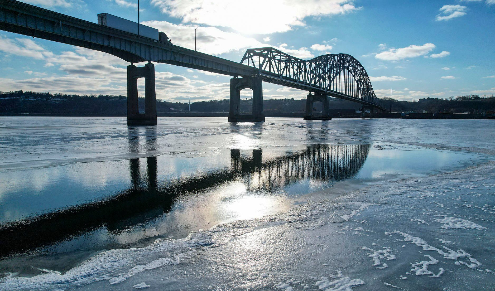 The Julien Dubuque Bridge is reflected in the Mississippi River on Wednesday.    PHOTO CREDIT: Dave Kettering
