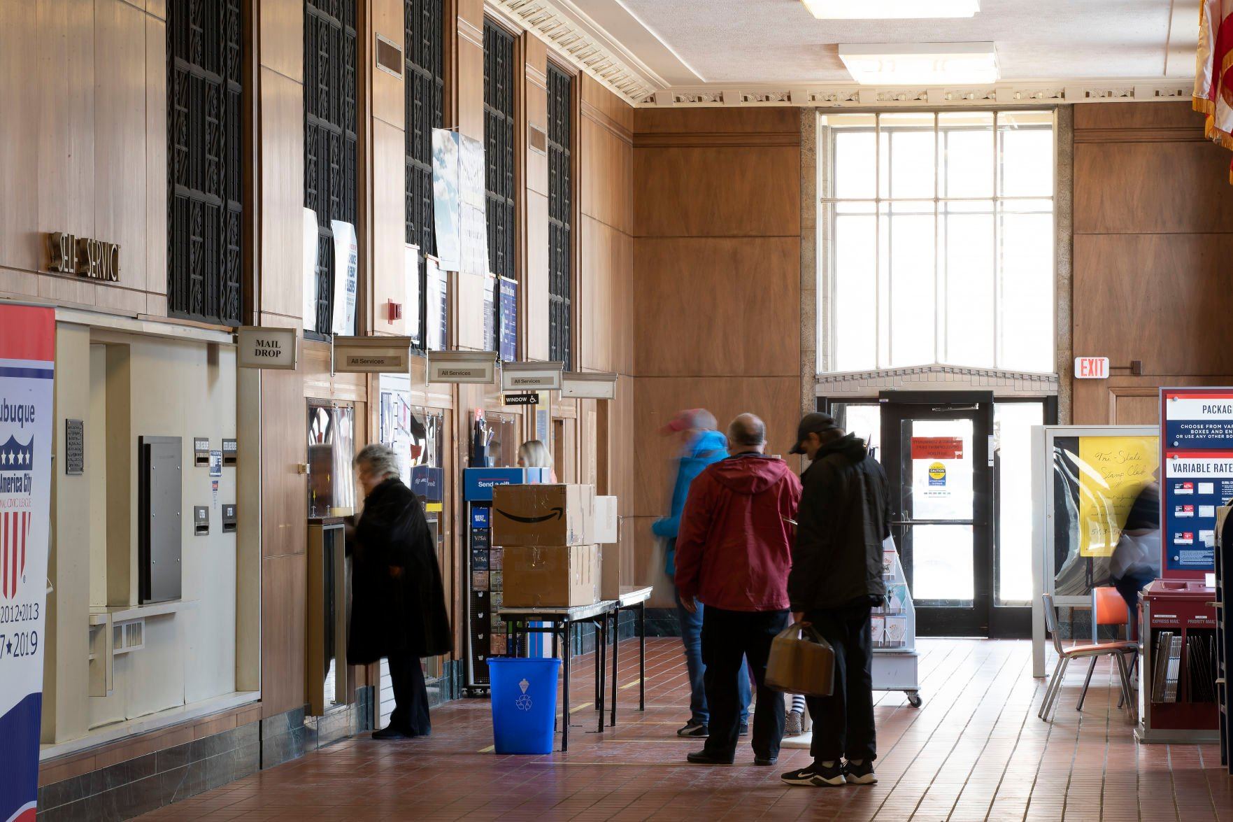 Customers stand in line in the post office’s lobby inside the Historic Federal Building in Dubuque on Wednesday.    PHOTO CREDIT: Stephen Gassman