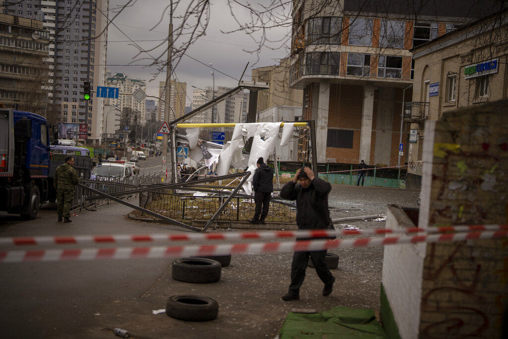 Police officers inspect an area after an apparent Russian strike in Kyiv Ukraine. Russia launched a wide-ranging attack on Ukraine today, hitting cities and bases with airstrikes or shelling, as civilians piled into trains and cars to flee.     PHOTO CREDIT: Emilio Morenatti