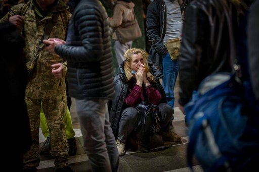 A woman reacts as she waits for a train trying to leave Kyiv, Ukraine, Thursday, Feb. 24, 2022. Russian troops have launched their anticipated attack on Ukraine. Big explosions were heard before dawn in Kyiv, Kharkiv and Odesa as world leaders decried the start of an Russian invasion that could cause massive casualties and topple Ukraine