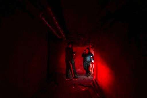 Ukrainian Emergency Situation employees stand in a shelter during Russian shelling, in Mariupol, Ukraine, Thursday, Feb. 24, 2022. Russia launched a wide-ranging attack on Ukraine on Thursday, hitting cities and bases with airstrikes or shelling, as civilians piled into trains and cars to flee. Ukraine