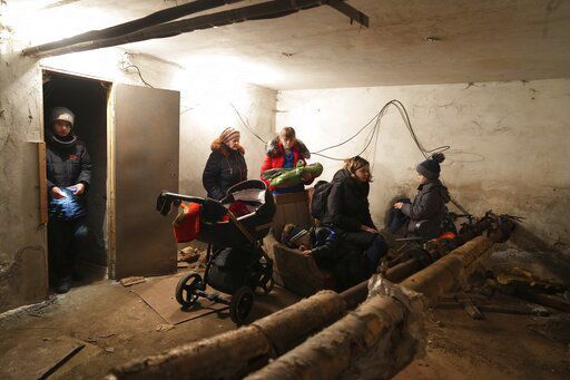 People gather in a shelter during Russian shelling, in Mariupol, Ukraine, Thursday, Feb. 24, 2022. Russia launched a wide-ranging attack on Ukraine on Thursday, hitting cities and bases with airstrikes or shelling, as civilians piled into trains and cars to flee. (AP Photo/Evgeniy Maloletka)    PHOTO CREDIT: Evgeniy Maloletka
