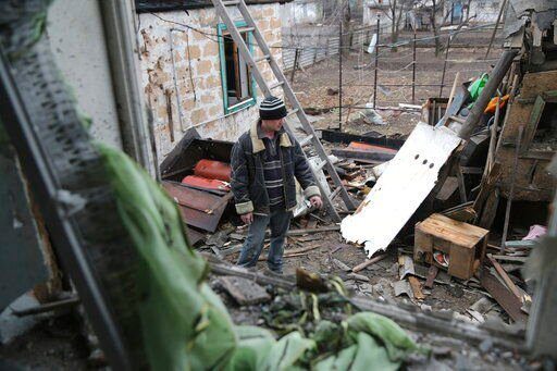 A local citizen stands between debris of his house following Ukrainian shelling in the territory controlled by pro-Russian militants, eastern Ukraine, Thursday, Feb. 24, 2022. Russian troops have launched a three-pronged assault on Ukraine that opened with air and missile strikes on Ukrainian military facilities and included ground troops invading from Crimea. (AP Photo/Alexei Alexandrov)    PHOTO CREDIT: Alexei Alexandrov