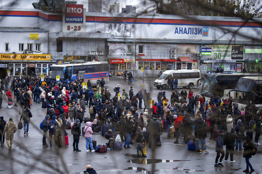 People try to get onto buses to leave Kyiv, Ukraine, Thursday, Feb. 24, 2022. Russia has launched a barrage of air and missile strikes on Ukraine early Thursday and Ukrainian officials said that Russian troops have rolled into the country from the north, east and south. (AP Photo/Emilio Morenatti)    PHOTO CREDIT: Emilio Morenatti